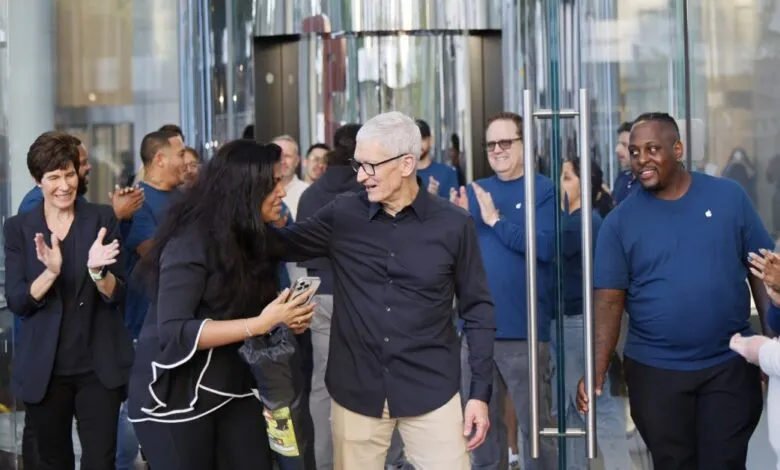 Tim Cook greeted by Apple employees, receiving applause and a photo opportunity.