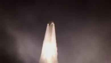 Rocket launch with bright plume against a dark sky.
