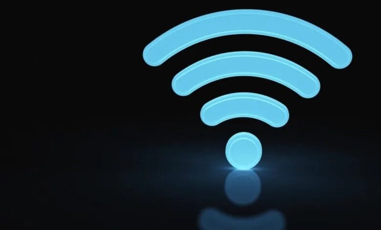 Glowing blue WiFi symbol on a reflective black surface.