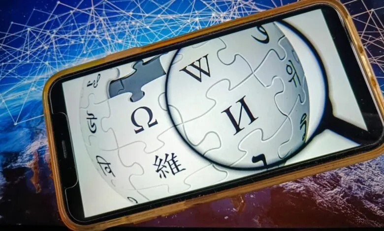 Smartphone displaying the Wikipedia logo against a network background.