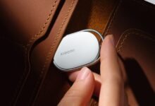Xiaomi tracker being placed in a brown leather wallet.