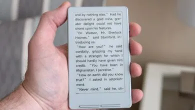 Hand holding an e-reader displaying text from a Sherlock Holmes story.