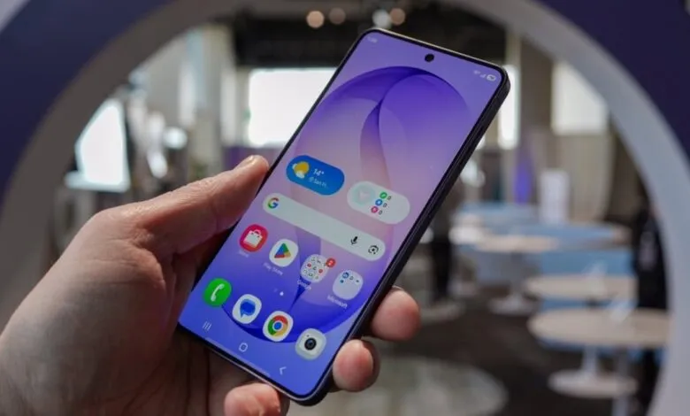 Hand holding smartphone with vibrant purple wallpaper and app icons.