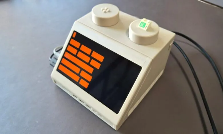 LEGO-like device with orange display and two top studs.