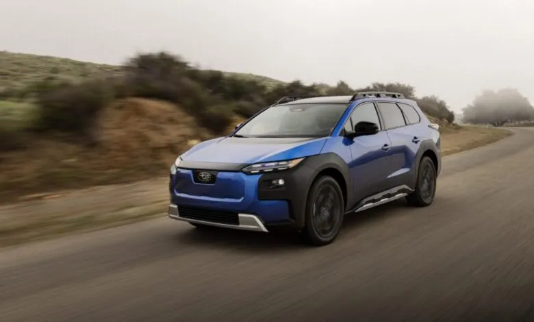 Blue 2026 Subaru Solterra driving on a winding road.