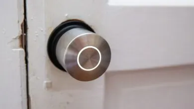 Smart lock installed on a white door with visible wear and tear.