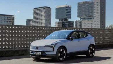 Cloud Blue Volvo EX30 electric SUV parked against a modern urban backdrop.