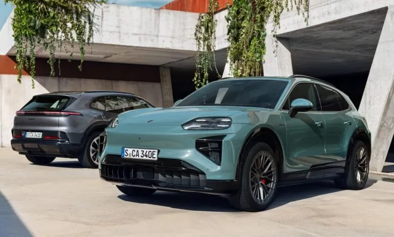 Two Porsche Macan EVs, one teal in front and one gray in back, parked outdoors.