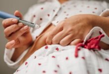 Person injecting insulin into abdomen with pen injector.