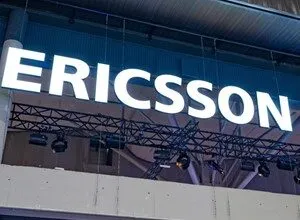 Illuminated Ericsson sign with white letters against a dark background.