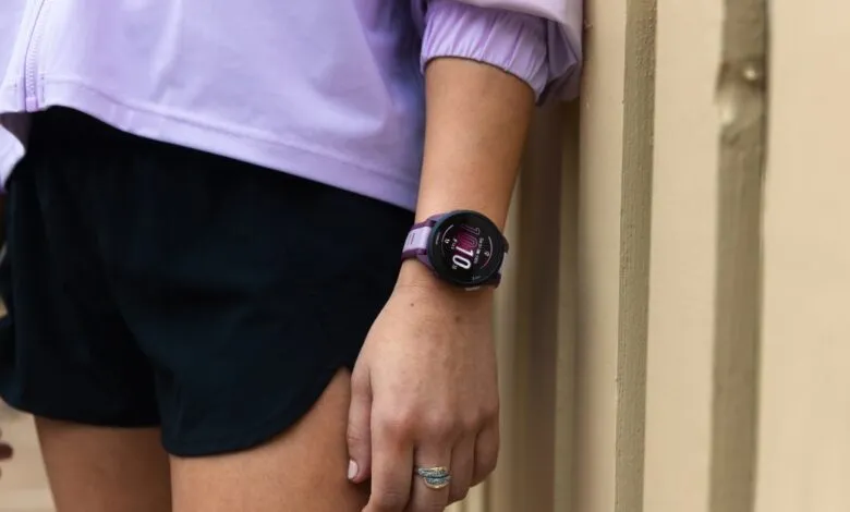 Close-up of a woman's wrist wearing a purple Garmin smartwatch.