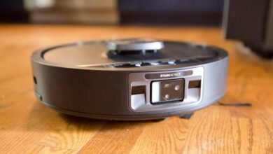 Robot vacuum cleaner on hardwood floor with stain detection feature.