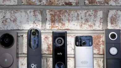 Five different smart video doorbells mounted on a brick wall.
