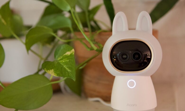 Aqara Camera Hub G3 with bunny ears next to a potted plant.