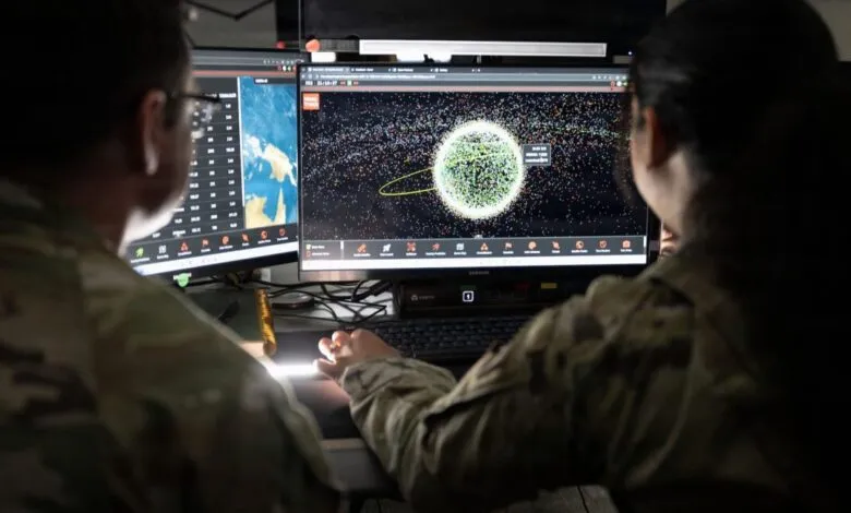 Two Space Force Guardians monitor satellite data on computer screens.