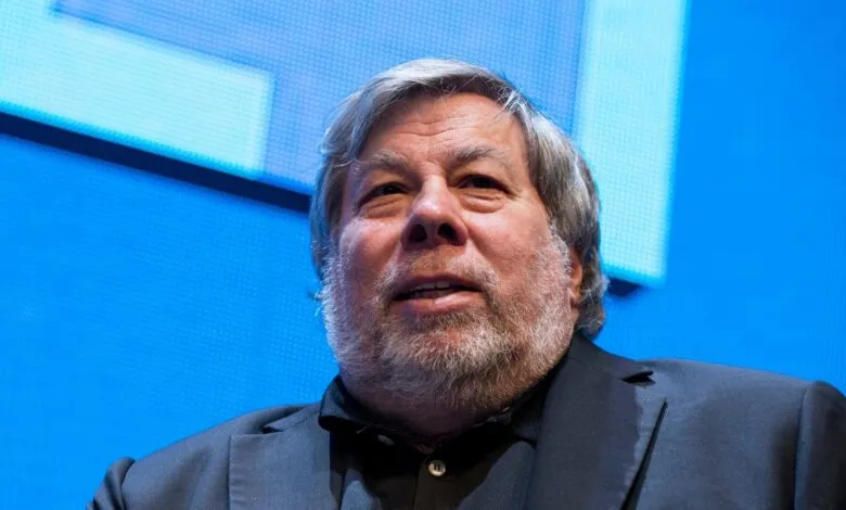 Steve Wozniak looks up with a slight smile against a blue background.