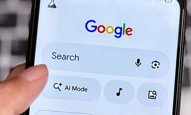 Close-up of a finger touching the search bar on the Google app on a smartphone.