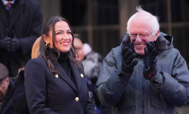 Alexandria Ocasio-Cortez and Bernie Sanders smiling outdoors.