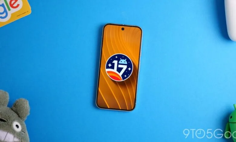 Android 17 logo on a smartphone screen, surrounded by toys.