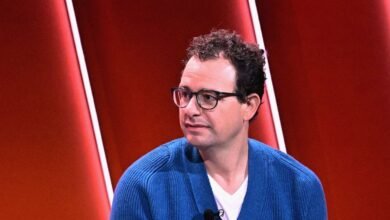 Dario Amodei, Anthropic CEO, wearing glasses and a blue sweater.