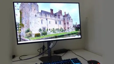 Computer monitor displays a castle scene with keyboard and mouse on a white desk.