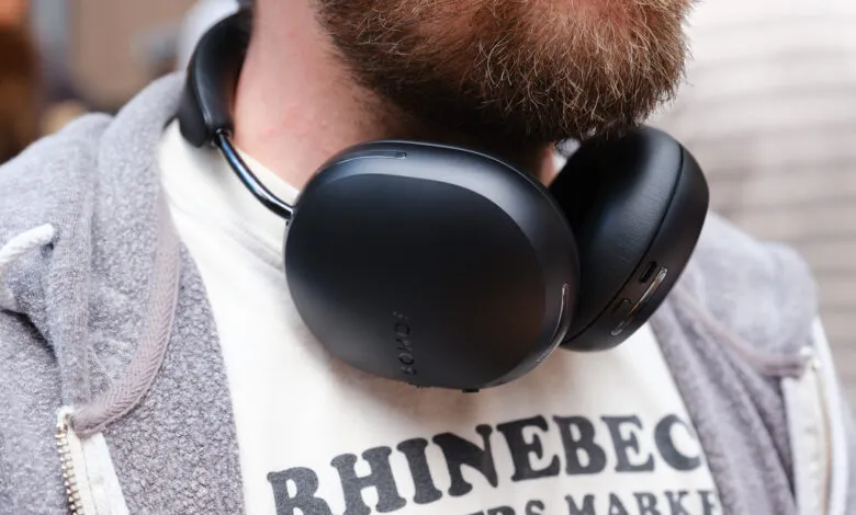 Black Sonos headphones around neck of person with beard and gray hoodie.
