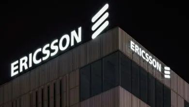 Ericsson building at night with illuminated logo and signage.