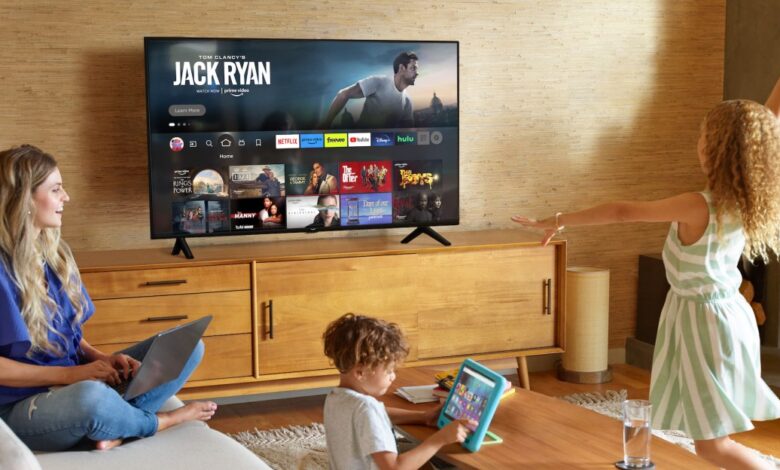 Family enjoying Fire TV in living room, woman on laptop, child with tablet.