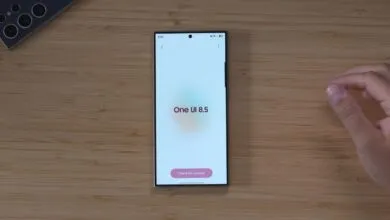 Samsung phone displaying One UI 8.5 on a wooden surface.