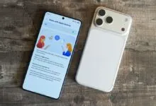 Two smartphones, one displaying 'Share with Apple devices' screen, on wood surface.