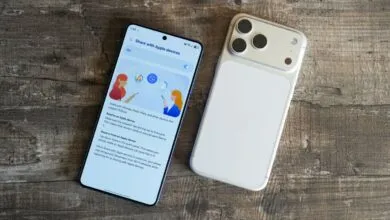 Two smartphones, one displaying 'Share with Apple devices' screen, on wood surface.