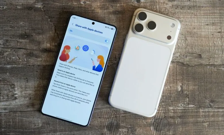 Two smartphones, one displaying 'Share with Apple devices' screen, on wood surface.
