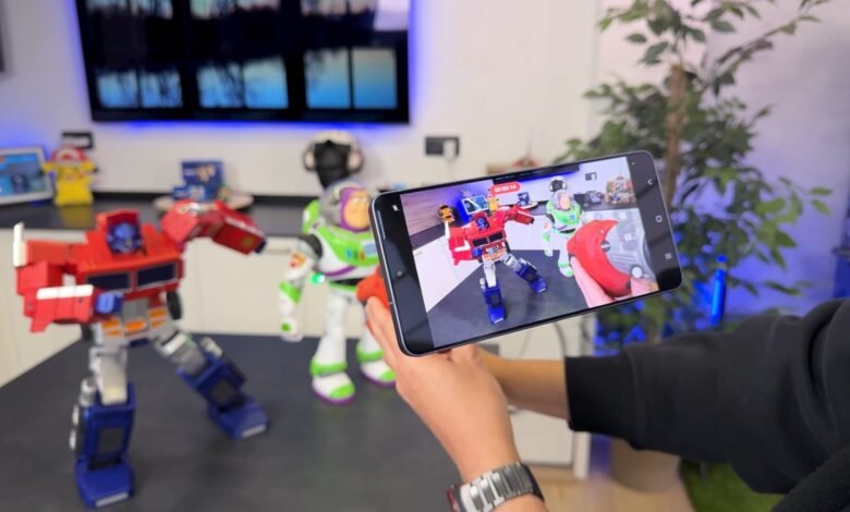 Person filming Optimus Prime and Buzz Lightyear toys with a smartphone.