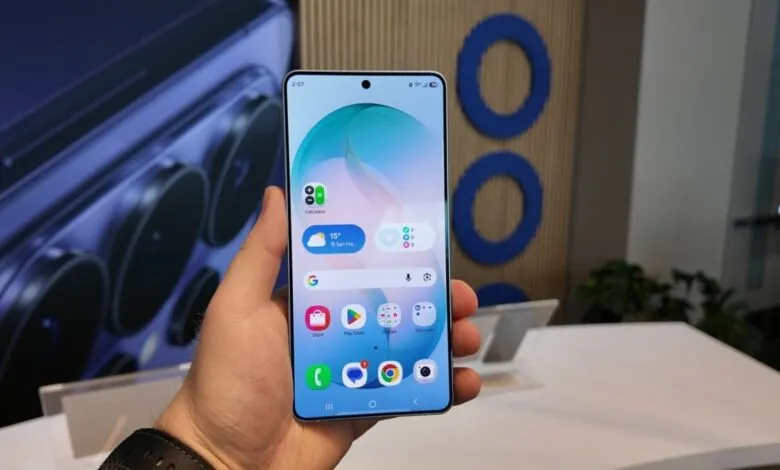 Hand holding smartphone displaying home screen with app icons.
