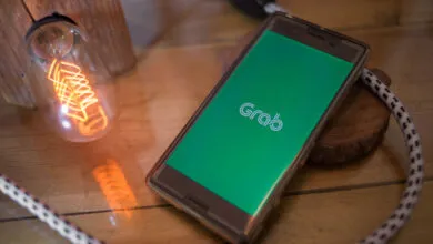 Sony smartphone displays the Grab app logo on a green screen.