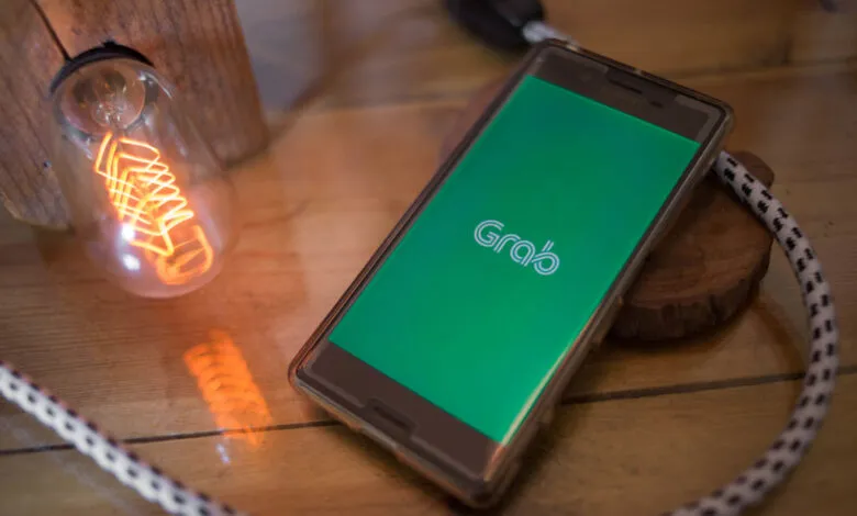 Sony smartphone displays the Grab app logo on a green screen.