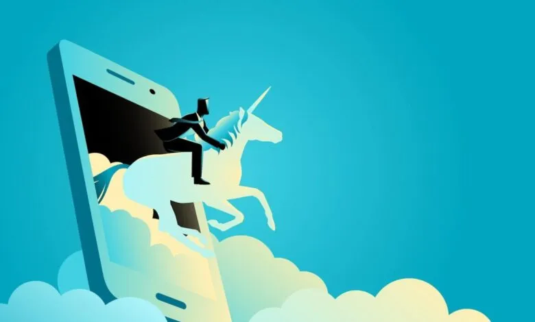 Businessman riding a unicorn emerging from a smartphone screen.
