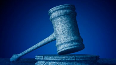 Stone gavel resting on a cracked base against a dark blue background.