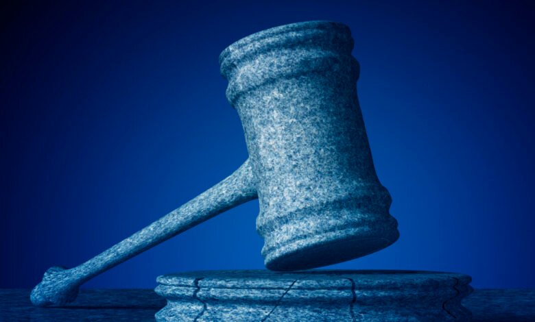 Stone gavel resting on a cracked base against a dark blue background.