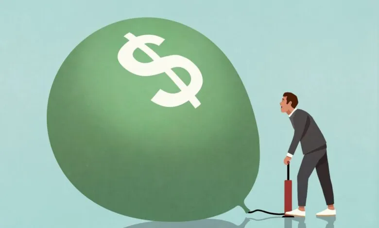 Man inflates dollar balloon, representing financial growth.