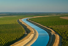 Aerial view of a canal winding through green farmland.