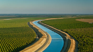 Aerial view of a canal winding through green farmland.