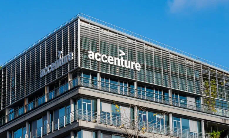 Accenture's French headquarters building with the company logo against a clear blue sky.