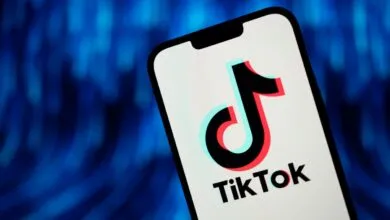TikTok logo displayed on a smartphone screen against a blue background.
