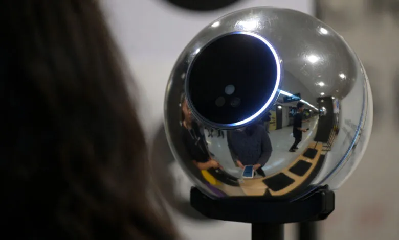 Close-up of a Worldcoin orb with reflections of people and the surrounding environment.