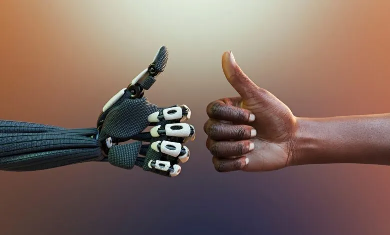 Robot and human hands giving thumbs up, symbolizing agreement or approval.