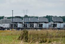 Rows of modular data center units with cooling systems, cloudy sky.