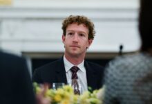 Mark Zuckerberg at a formal dinner, wearing a suit and tie.