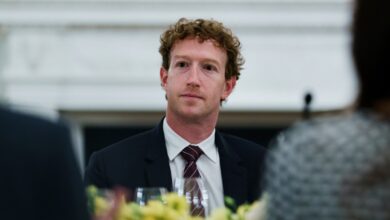 Mark Zuckerberg at a formal dinner, wearing a suit and tie.