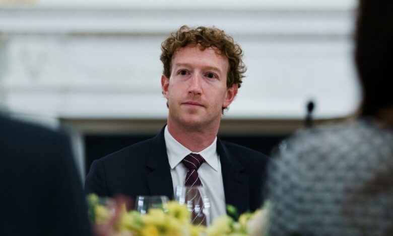 Mark Zuckerberg at a formal dinner, wearing a suit and tie.